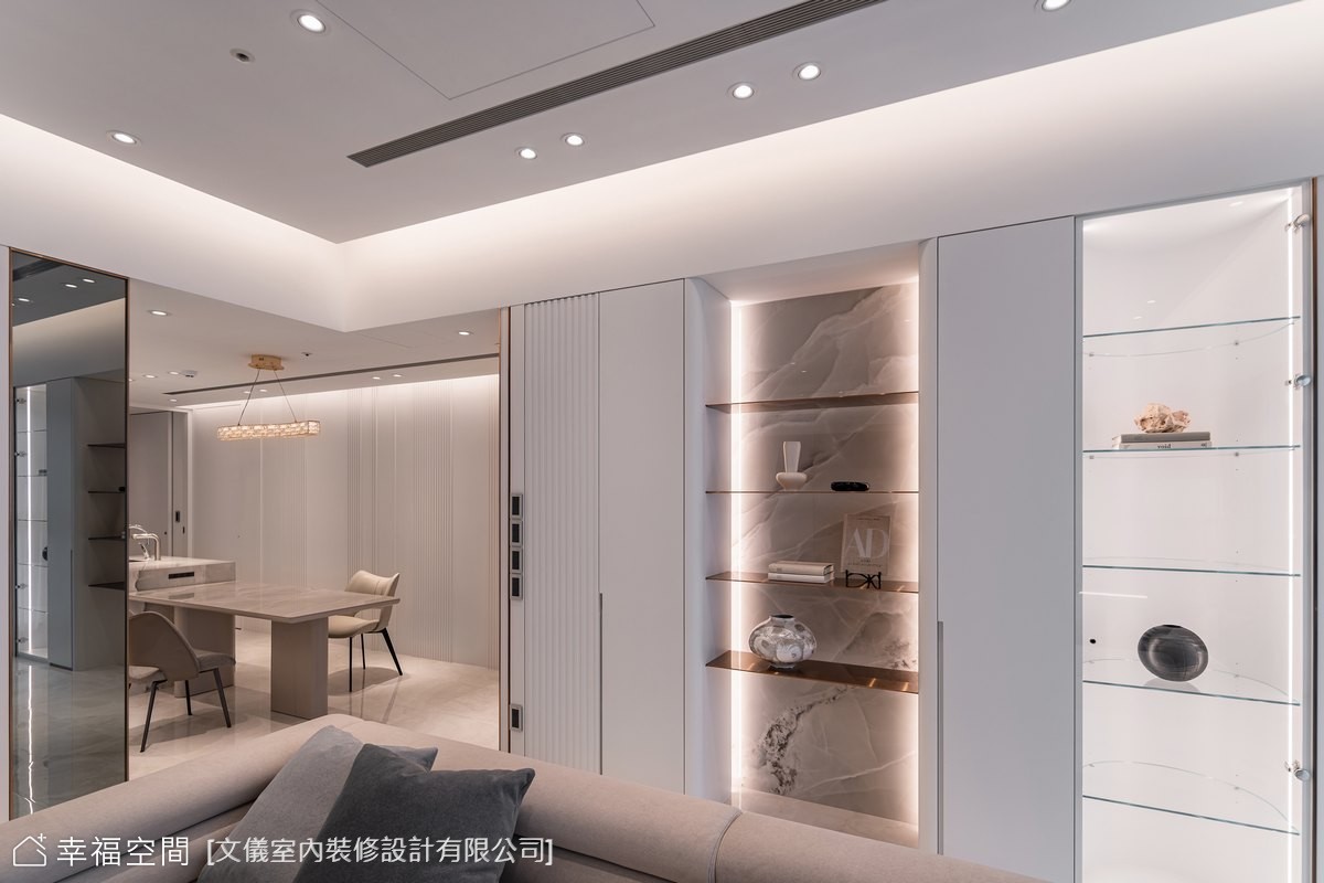 客餐廳採開放式設計，以大理石電視牆與展示櫃創造視覺焦點，搭配間接照明營造溫暖氛圍。