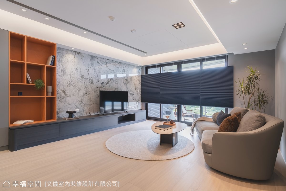 現代風客廳以灰色石材電視牆作為視覺焦點,搭配開放式層架和舒適沙發,營造簡約時尚的居家氛圍。