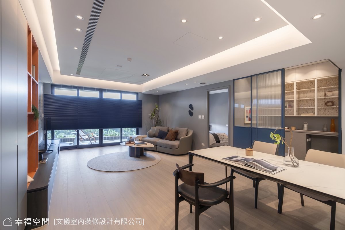 現代風客廳以灰藍色調營造沉穩氛圍,搭配開放式設計串聯客廳與餐廳,提升空間通透感與機能性。