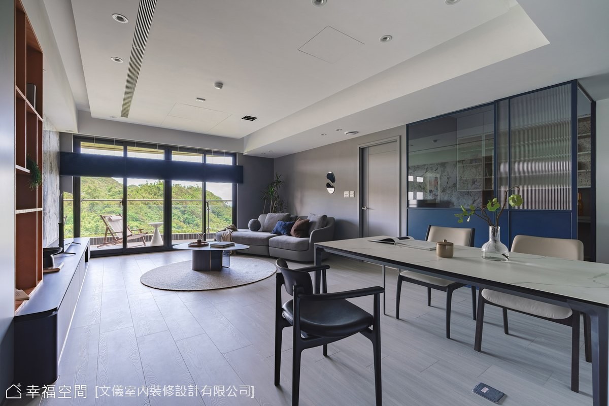以現代簡約風格打造客餐廳空間,運用藍色玻璃隔屏區分場域,同時保有視覺穿透感與隱私,展現時尚與實用兼具