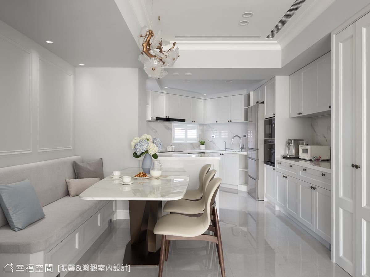 美式風格餐廚空間採用開放式設計，白色大理石餐桌搭配灰色沙發，營造出寬敞明亮的用餐環境。