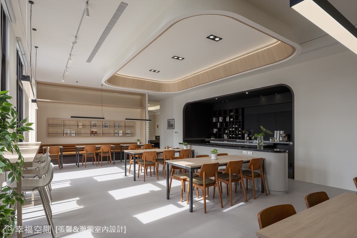 寬敞的現代辦公空間結合餐飲區，以簡潔設計和木質餐桌椅營造舒適氛圍，透過弧形天花板與線條燈帶增添層次感
