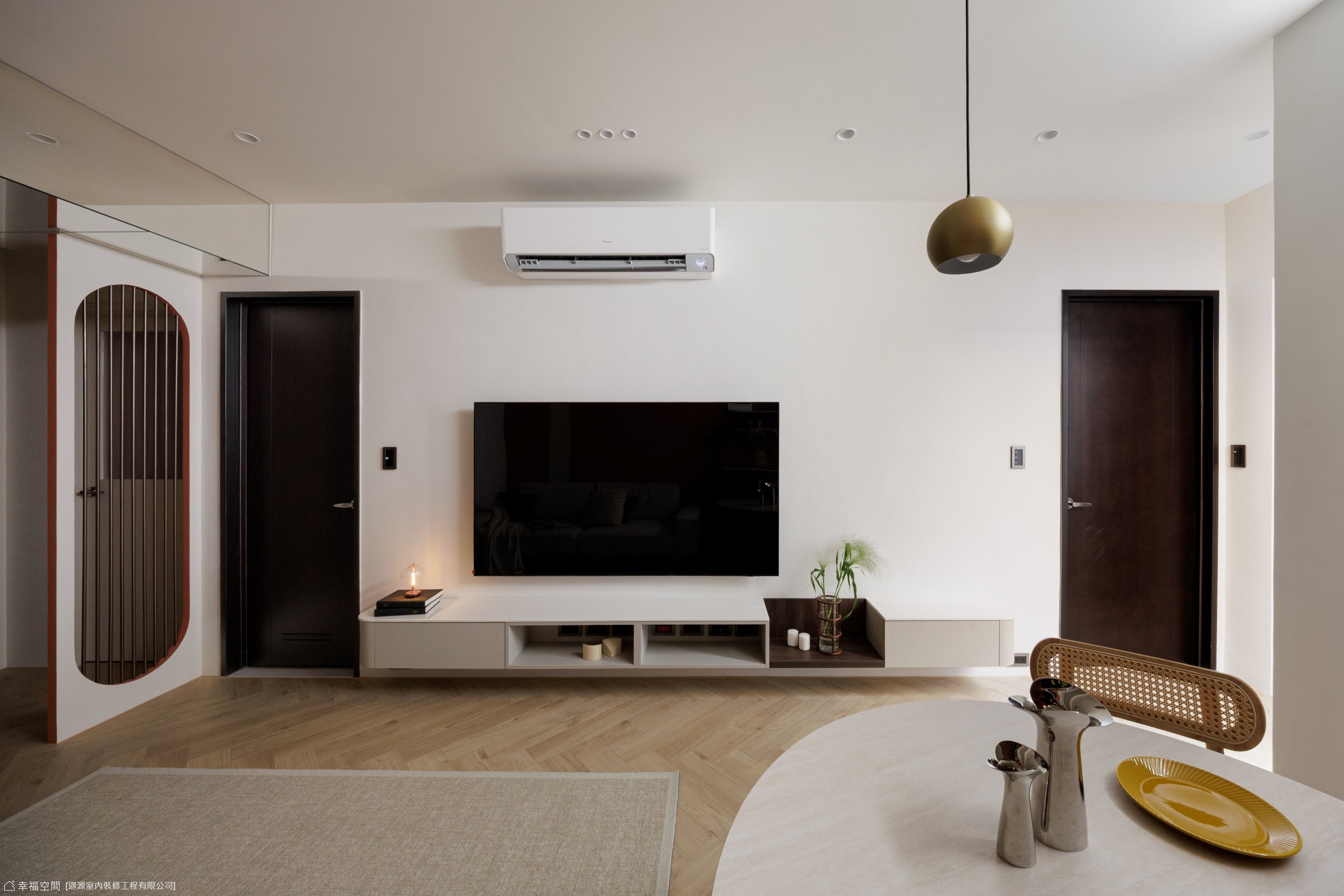 此設計將客廳與餐廳巧妙結合,電視牆面簡潔搭配木質地板,營造出寬敞且溫馨的現代居家氛圍。