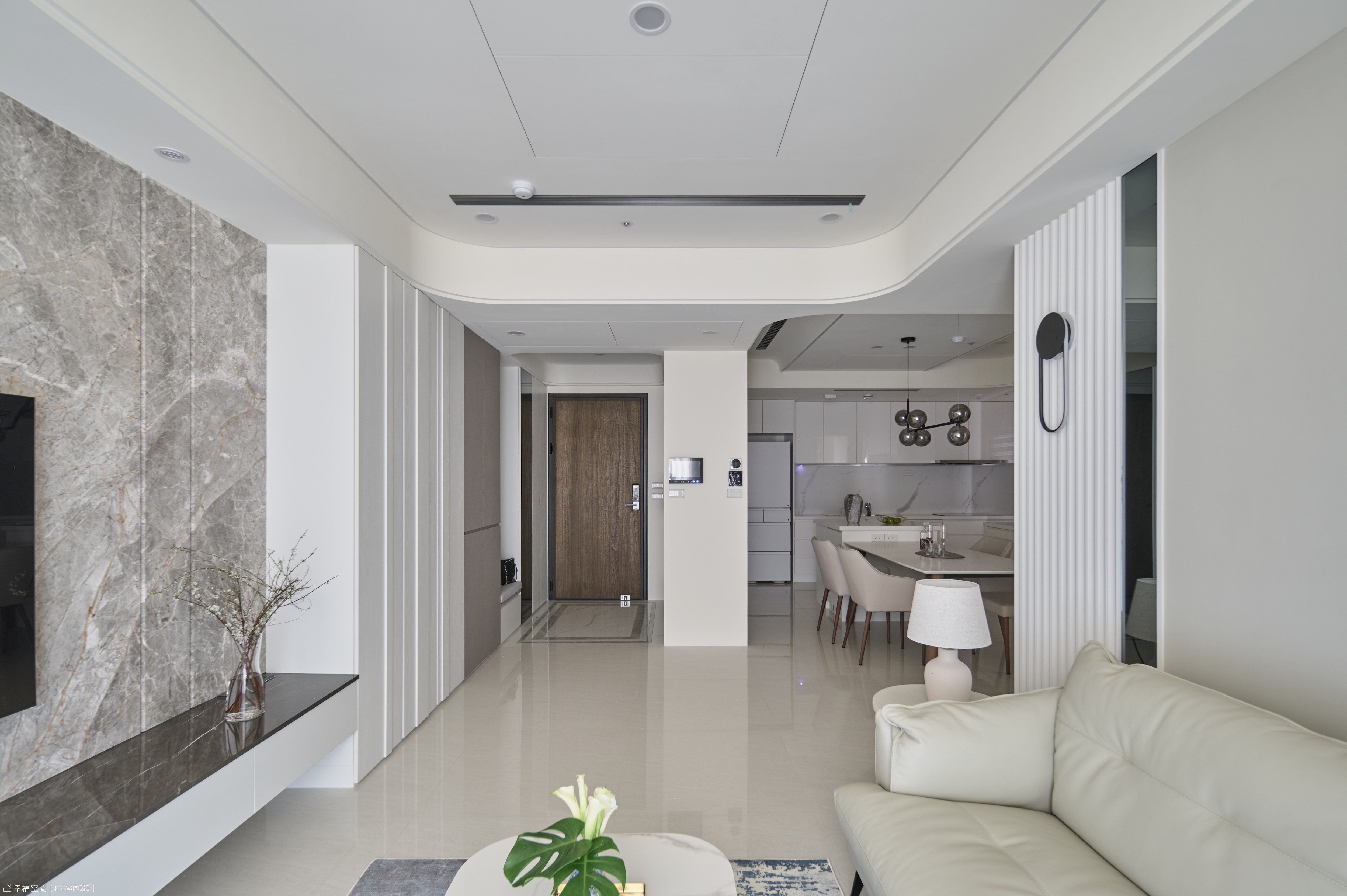 客廳與餐廳採用開放式設計,搭配淺色系家具與大理石牆面,營造寬敞明亮的現代居家氛圍。