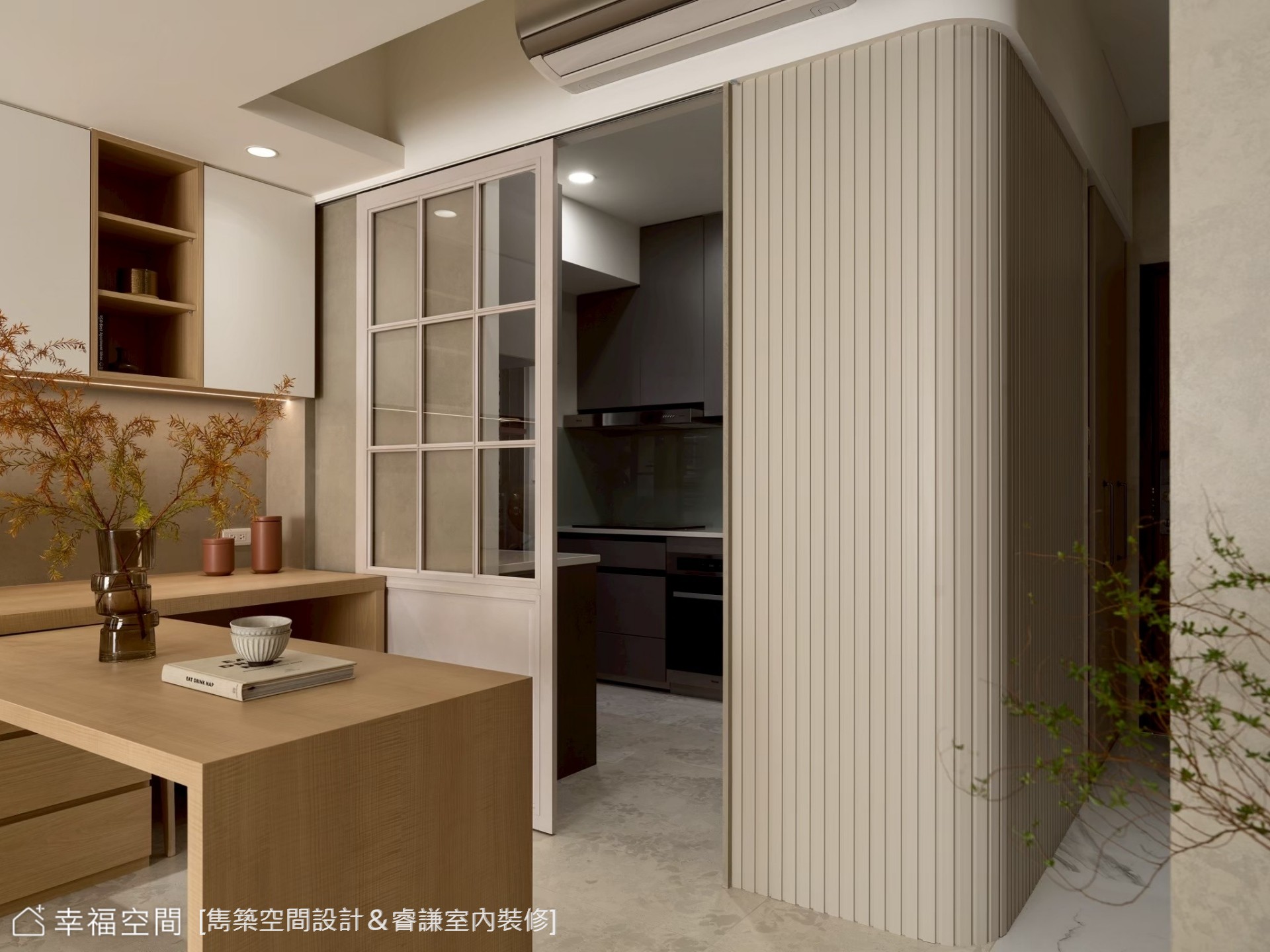 現代風餐廚空間以木質中島連結餐桌,搭配白色櫃體與灰色地坪,營造簡潔實用的用餐環境。