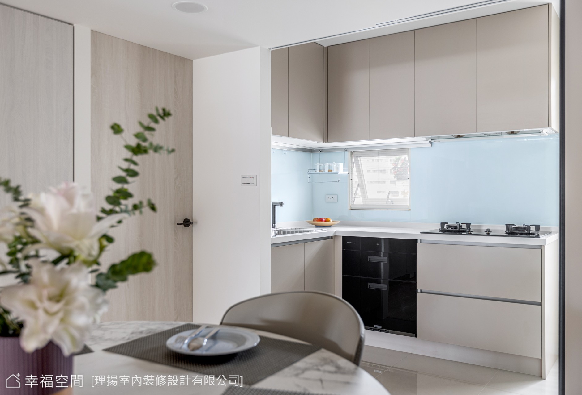現代風格餐廚空間採用開放式設計,淺色系廚具搭配藍色防濺板,營造簡潔明亮的用餐氛圍。