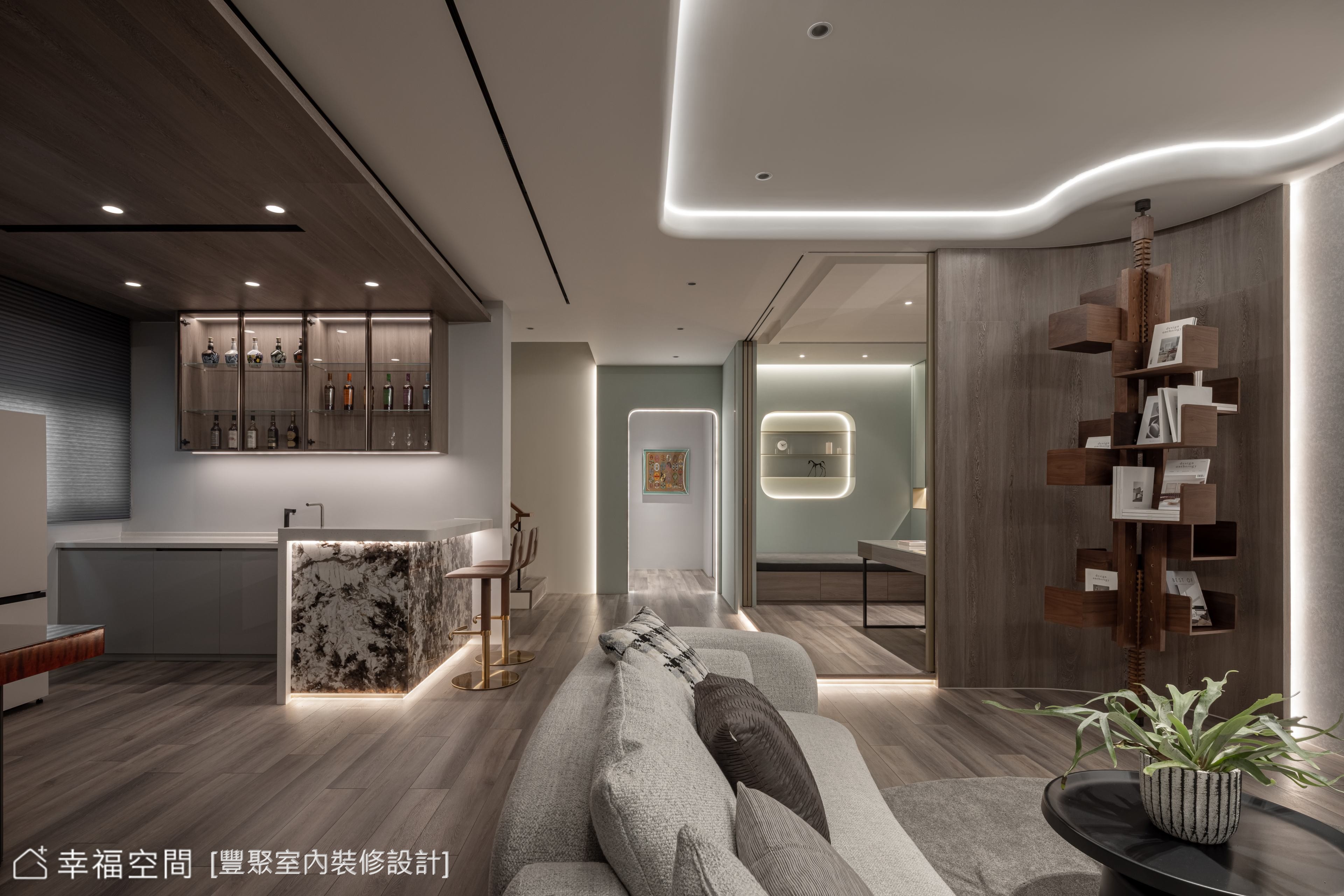奢華風格客廳搭配開放式吧檯設計,利用線條感燈光營造空間層次,並選用木質與石材的異材質結合,展現低調奢