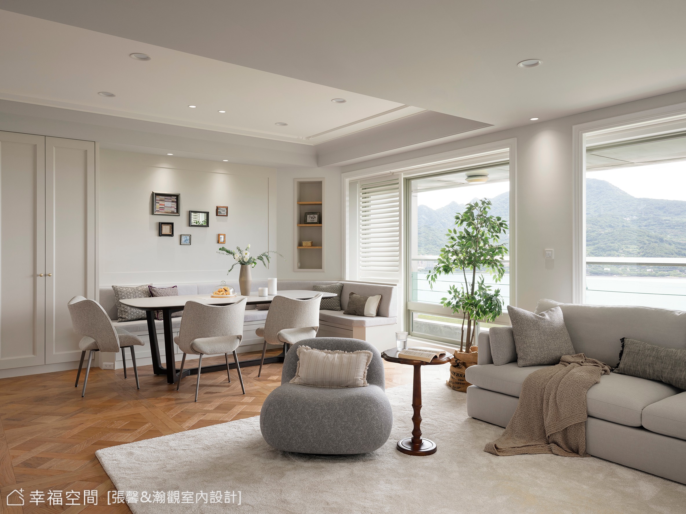 客廳與餐廳採用開放式設計,讓空間感更為寬敞,並利用灰白色系搭配木質元素,營造出簡潔舒適的現代居家氛圍