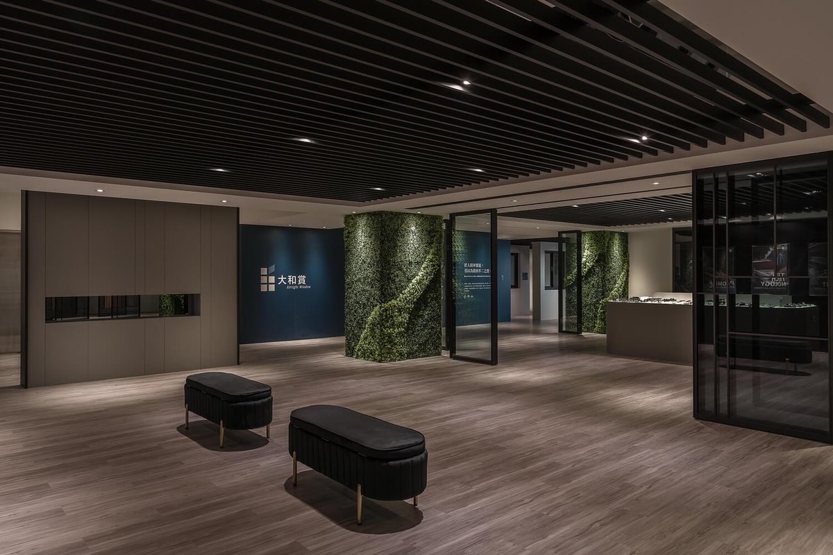從另一個角度看展示大廳，深色座椅與淺色木地板形成對比，增添視覺趣味。
