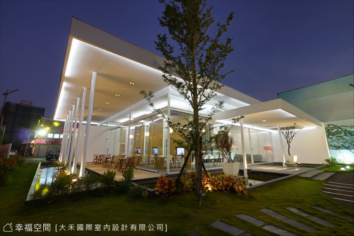 蹲伏於綠地上待飛的白色建築