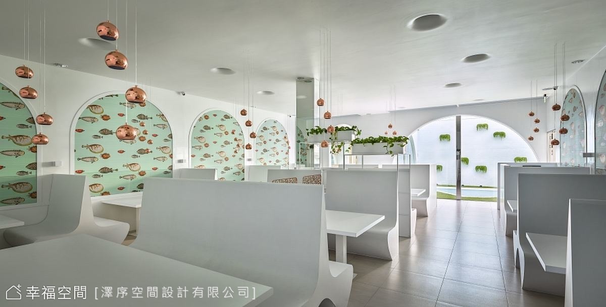 用餐區的卡座設計，提供舒適的用餐空間，牆面點綴著可愛的魚群圖案，增添活潑感。