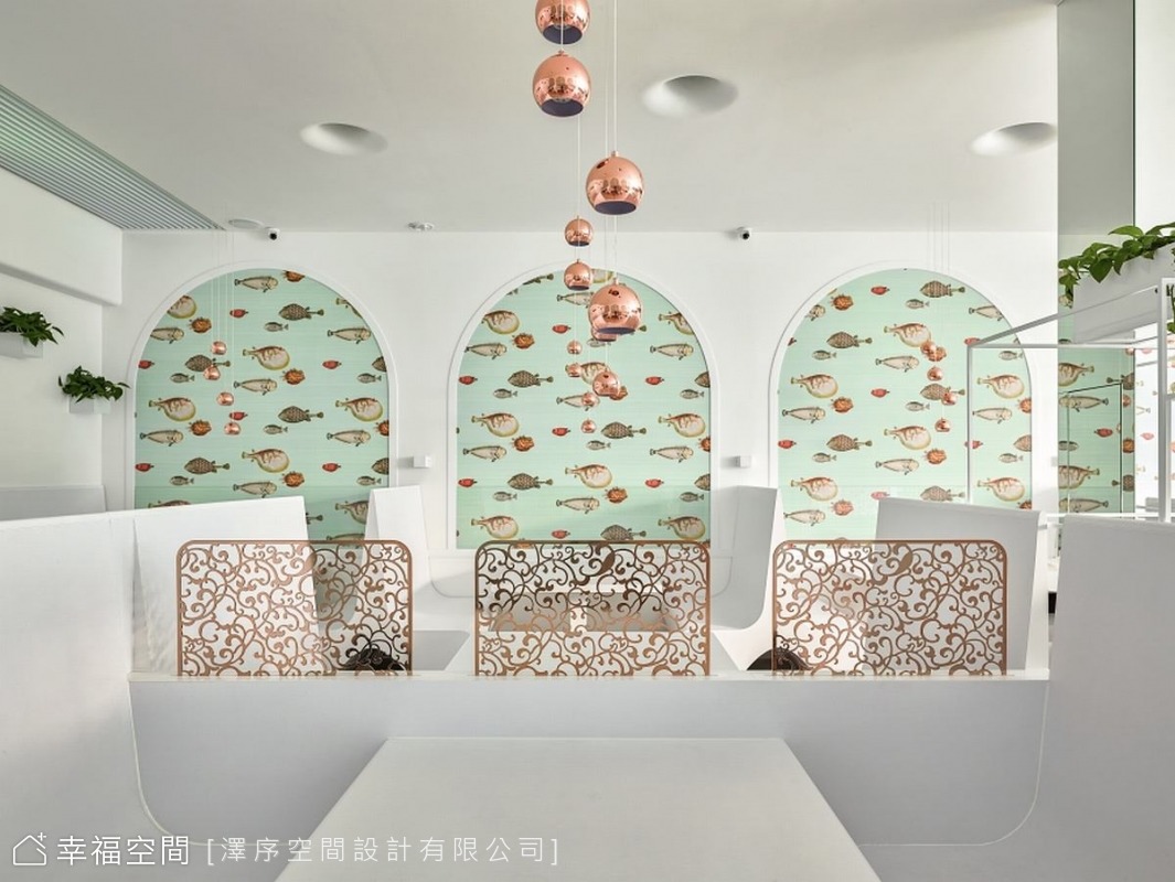 牆面的魚群圖案與金屬隔屏，為簡約的空間增添了設計感。