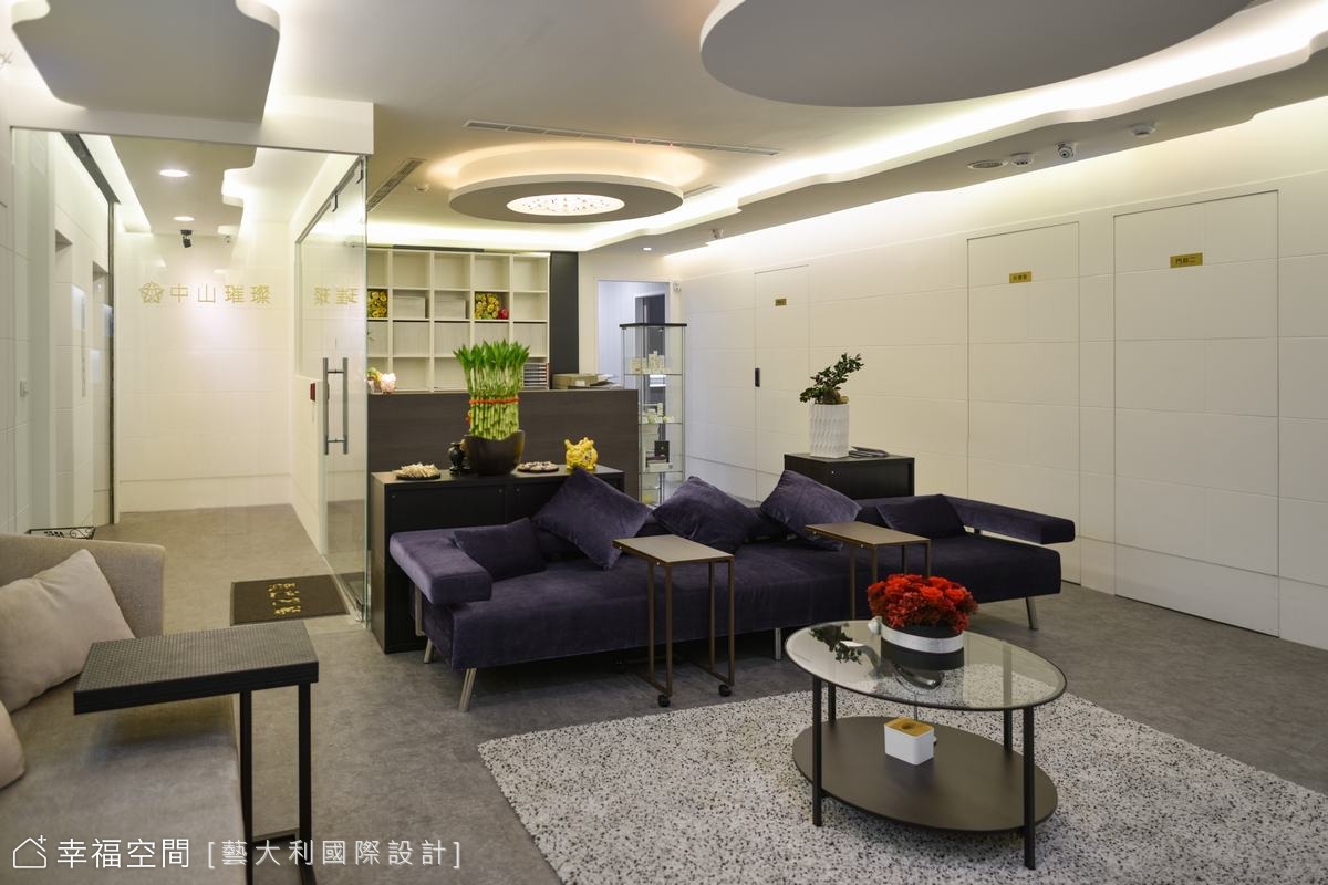 接待區全景，深紫色沙發與溫暖燈光形成對比。